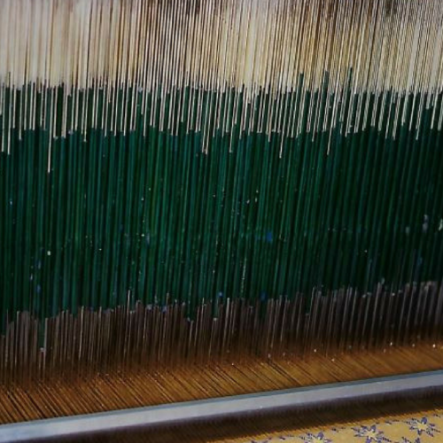 Close up of Jacquard fabric being woven on a loom